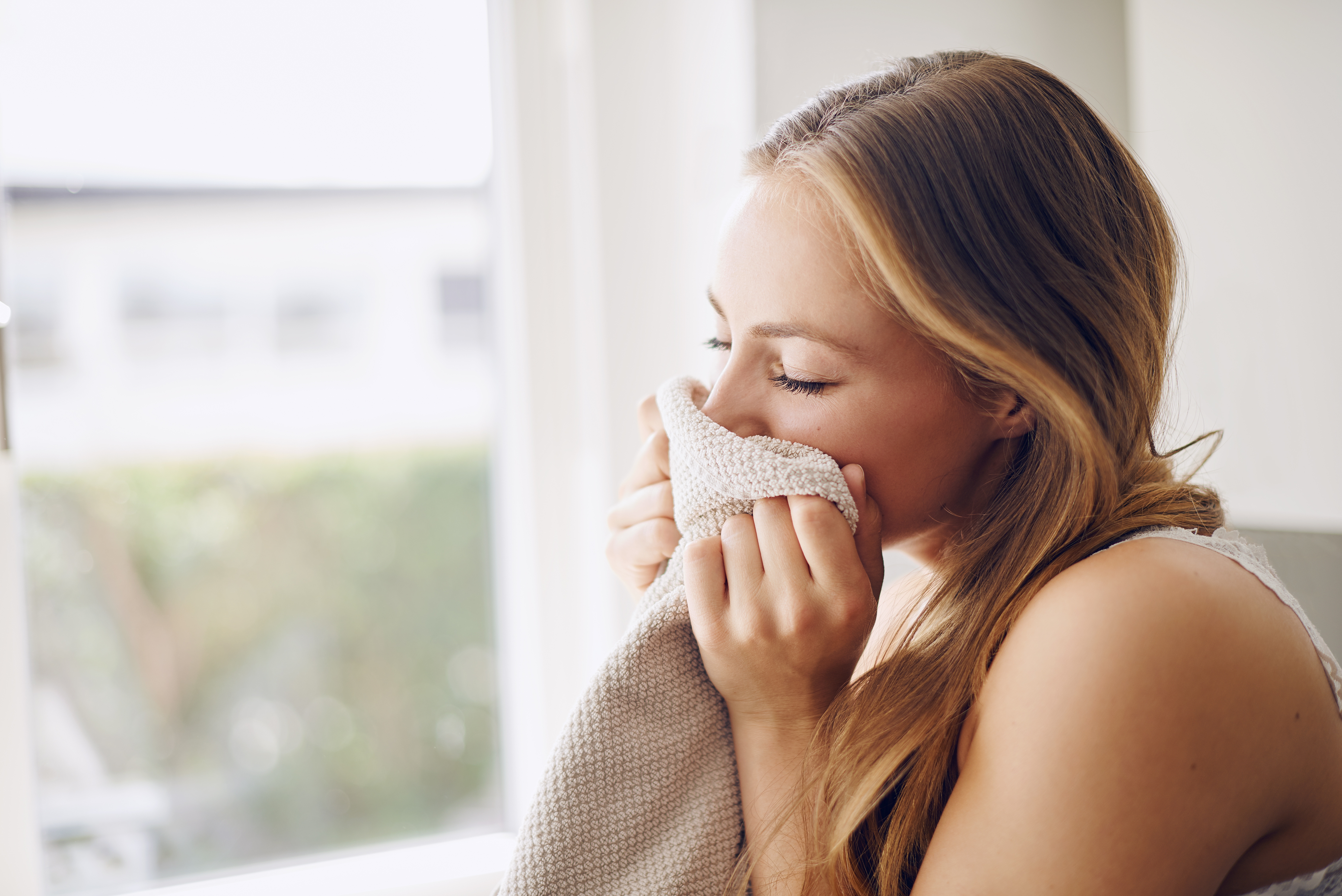 Woman Smelling Clean Towel